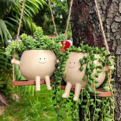 Hanging face planter styled with greenery outdoors