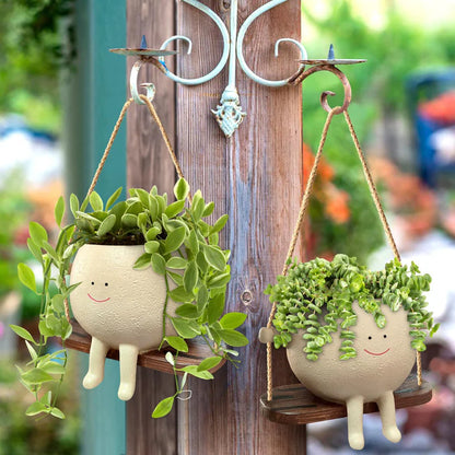 Multiple hanging face planters displayed on porch