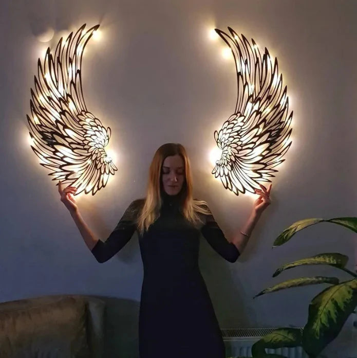Woman holding iron angel wings wall art for size reference