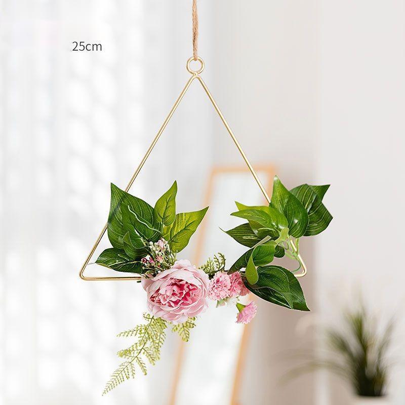 Close-up of the artificial flowers woven into the iron frame of the handmade wall hanging
