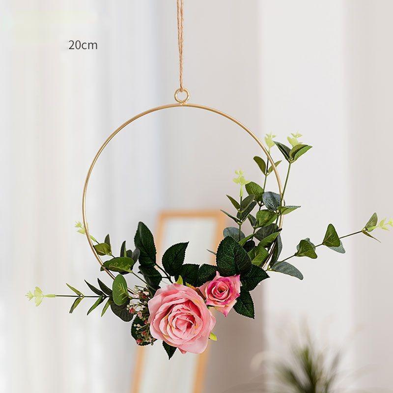 Hand pressing a loose flower head back into position on the iron wall hanging frame
