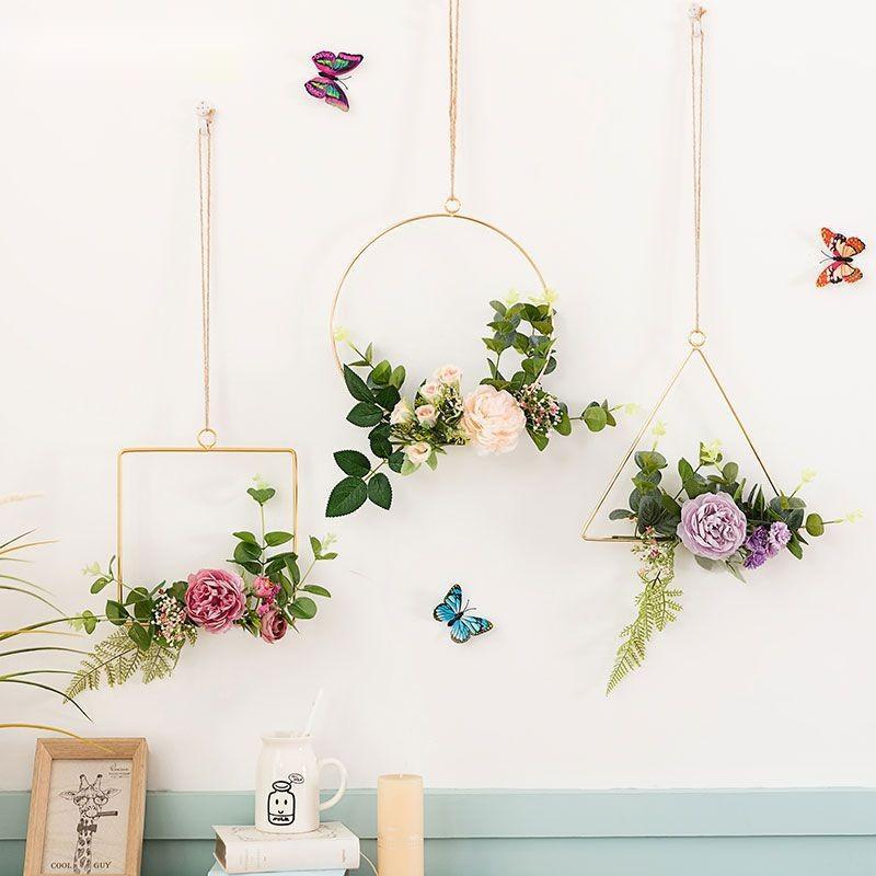 Iron and artificial flower wall art hanging above a bedroom headboard as a decorative accent
