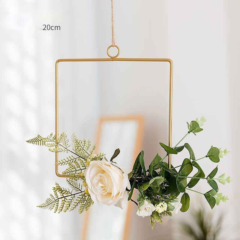 Iron wall hanging with artificial flowers flat lay on a neutral surface showing full piece
