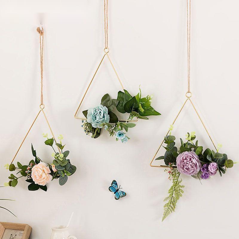 Iron wall hanging with artificial flowers looking the same after months with no watering needed

