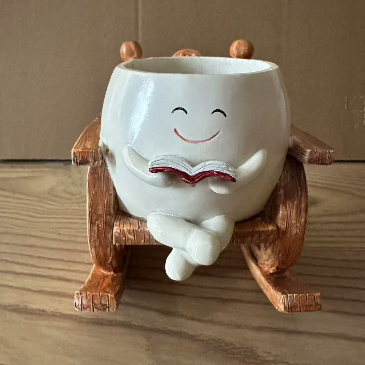 Lady rocking chair resin planter close up dark background
