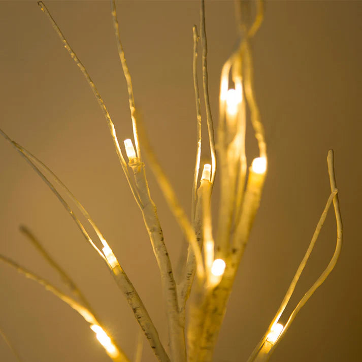 Close up of LED lights wrapped around birch tree branches
