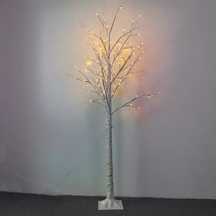 LED birch tree lights glowing beside window
