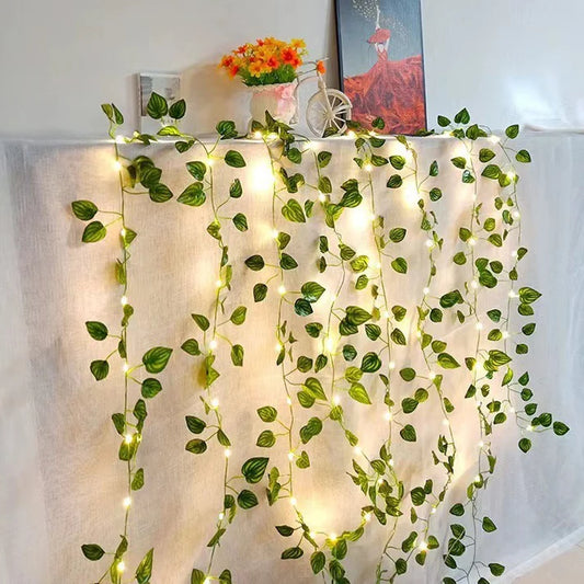 Green leaf copper wire LED string lights displayed in indoor room decoration setting