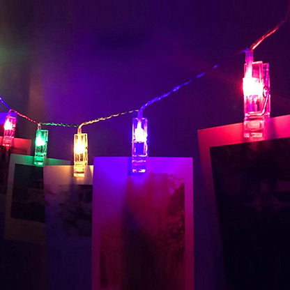 Colorful LED photo holder string lights displaying photos on wall
