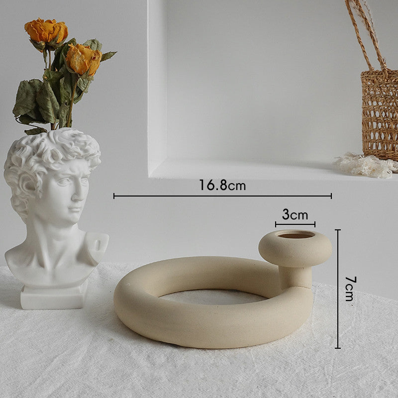 Nordic matte ceramic vase with dried botanicals on a bedside table beside a lamp
