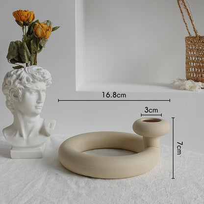 Nordic matte ceramic vase with dried botanicals on a bedside table beside a lamp
