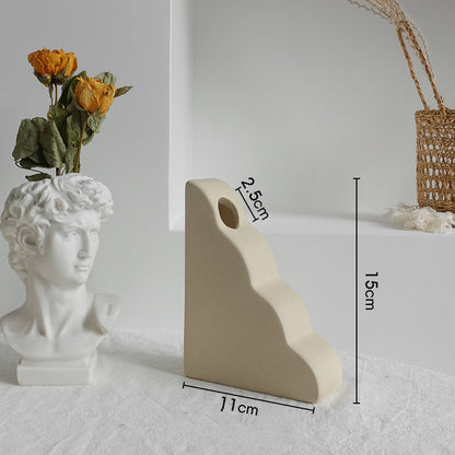 Matte ceramic vase styled on a bookshelf beside books and small decor in a Scandinavian room

