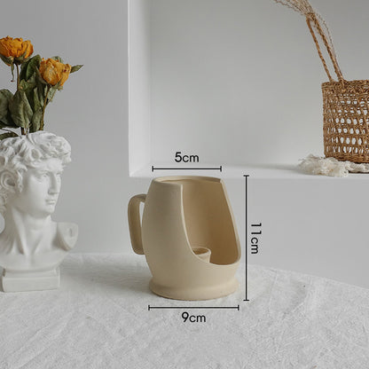 Matte ceramic vase in a Japandi styled shelf display with minimal objects and warm lighting
