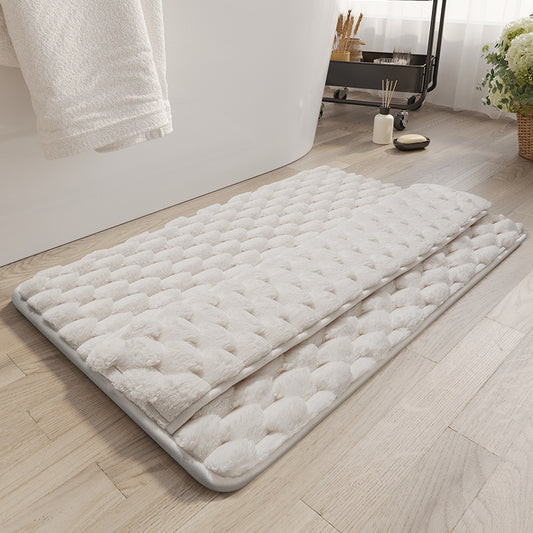 Gray memory foam bathroom mat placed at the exit of a shower on white tile floor
