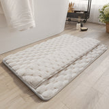 Gray memory foam bathroom mat placed at the exit of a shower on white tile floor