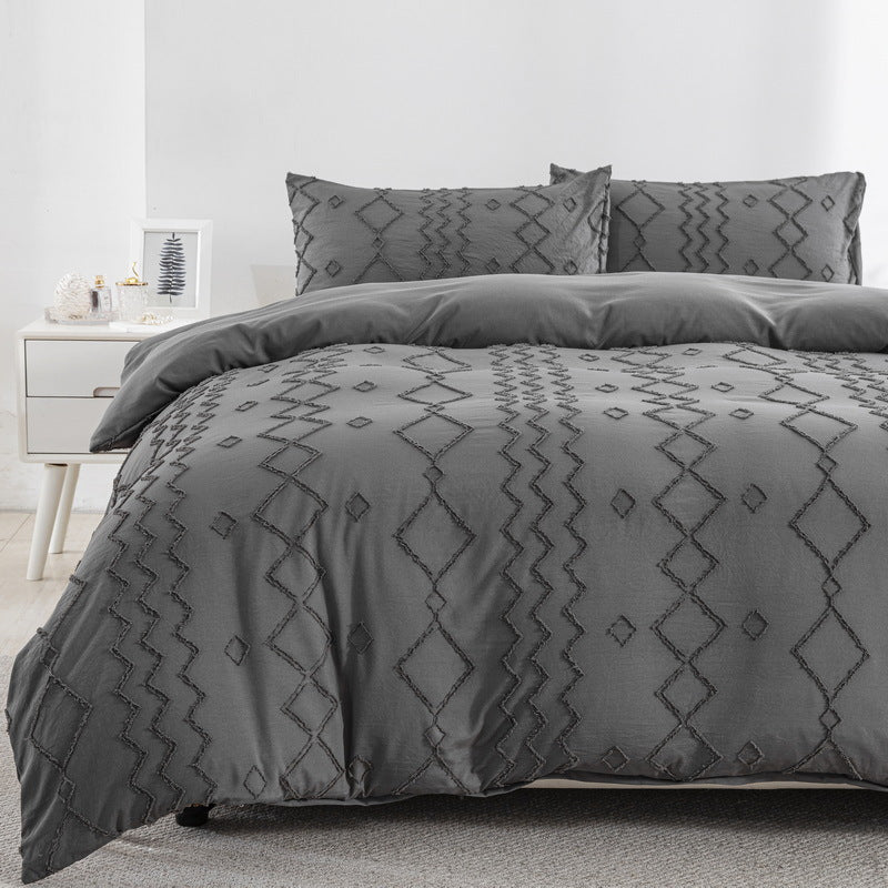 Gray pattern comforter set on a bed in a bedroom setting