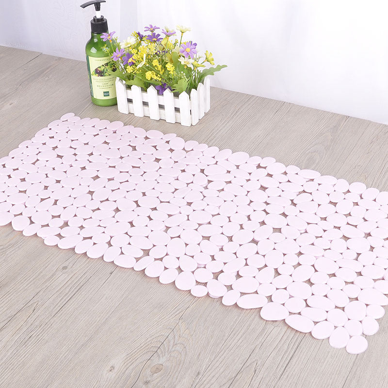 Pebble design non slip PVC mat in a clean modern white tile bathroom setting
