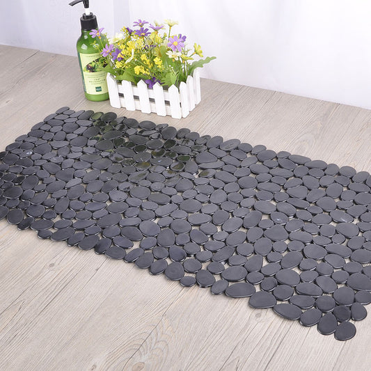 Pebble design PVC non slip bathroom mat lying flat on a wet shower floor
