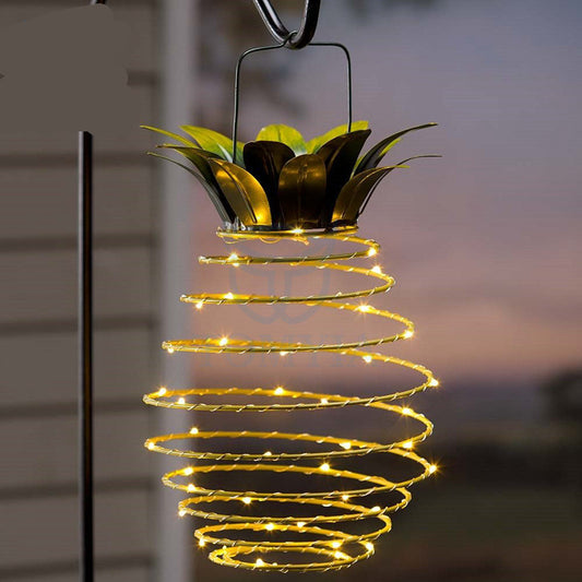 Pineapple solar garden light hanging on pole at night