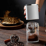 Portable electric coffee grinder on table with coffee beans setup