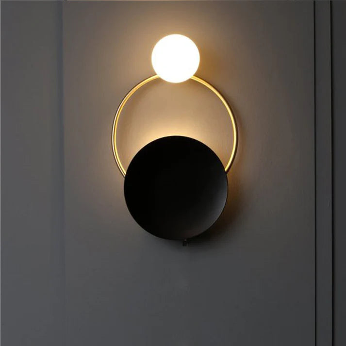 Post modern ring wall lamp warm light on dark wall bedroom setting