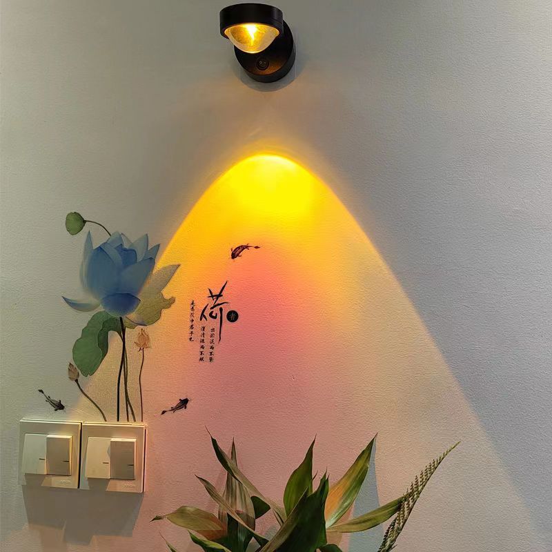 USB cable plugged into the rechargeable sunset wall lamp for charging on a nightstand
