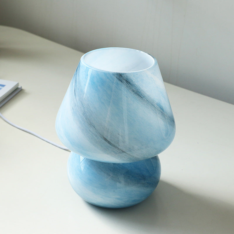 Pink retro glass USB table lamp used as a decorative accent on a bedroom desk
