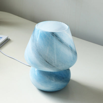 Pink retro glass USB table lamp used as a decorative accent on a bedroom desk
