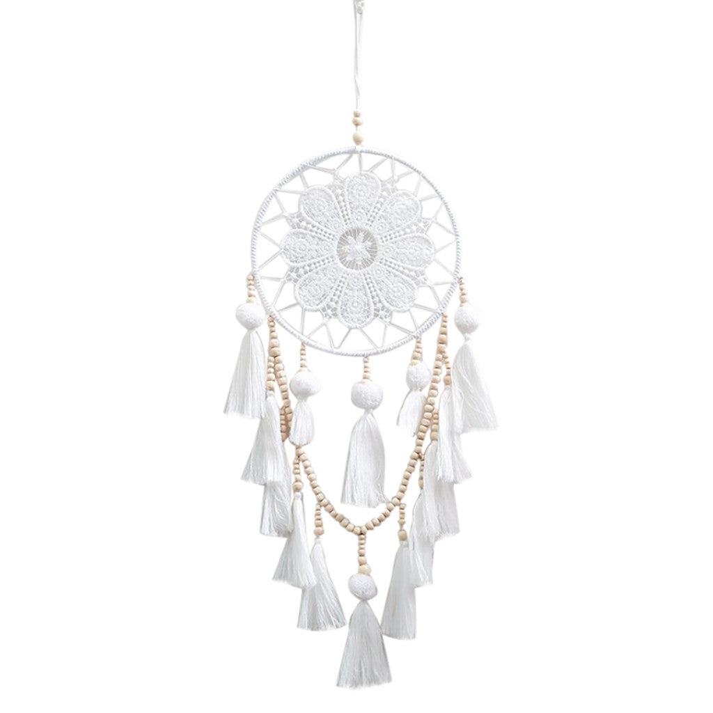 Romantic decorative dream catcher hanging beside a bedroom window in a boho styled room
