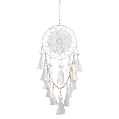 Romantic decorative dream catcher hanging beside a bedroom window in a boho styled room
