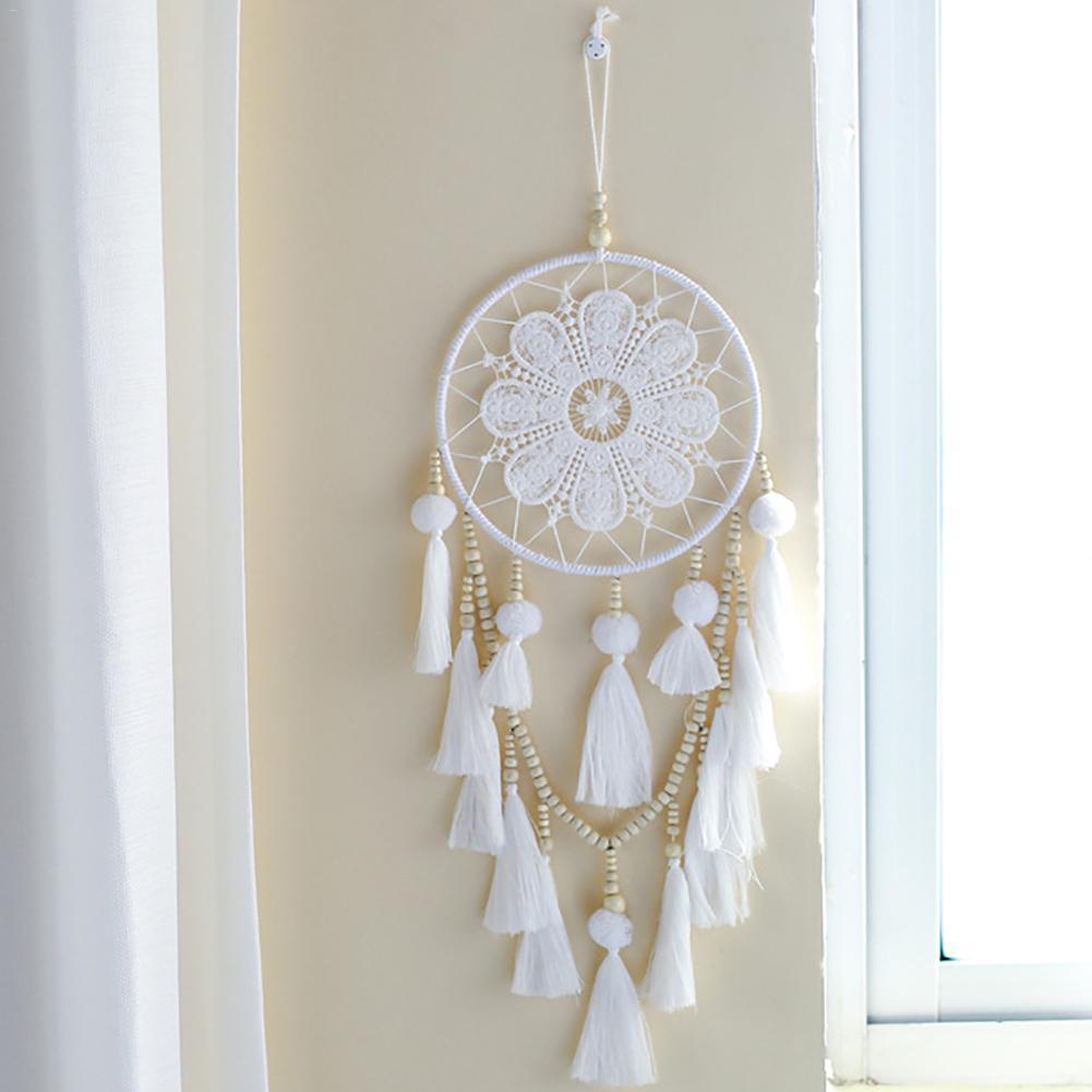 Romantic boho wall dream catcher hanging on a living room wall beside a sofa
