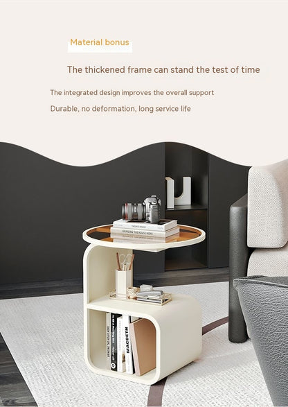Black metal frame round glass side table used as a bedside table in a modern bedroom
