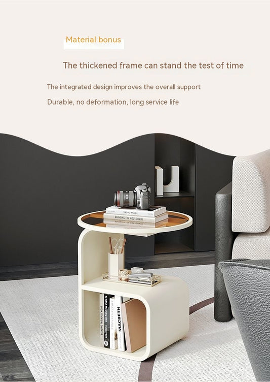 Black metal frame round glass side table used as a bedside table in a modern bedroom

