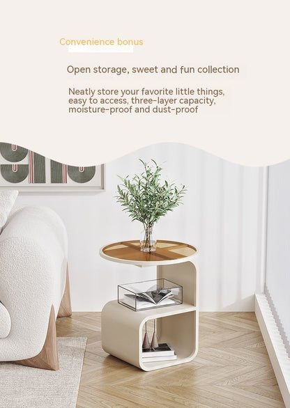 Black round glass side table beside a lounge chair in a home office as an arm reach surface

