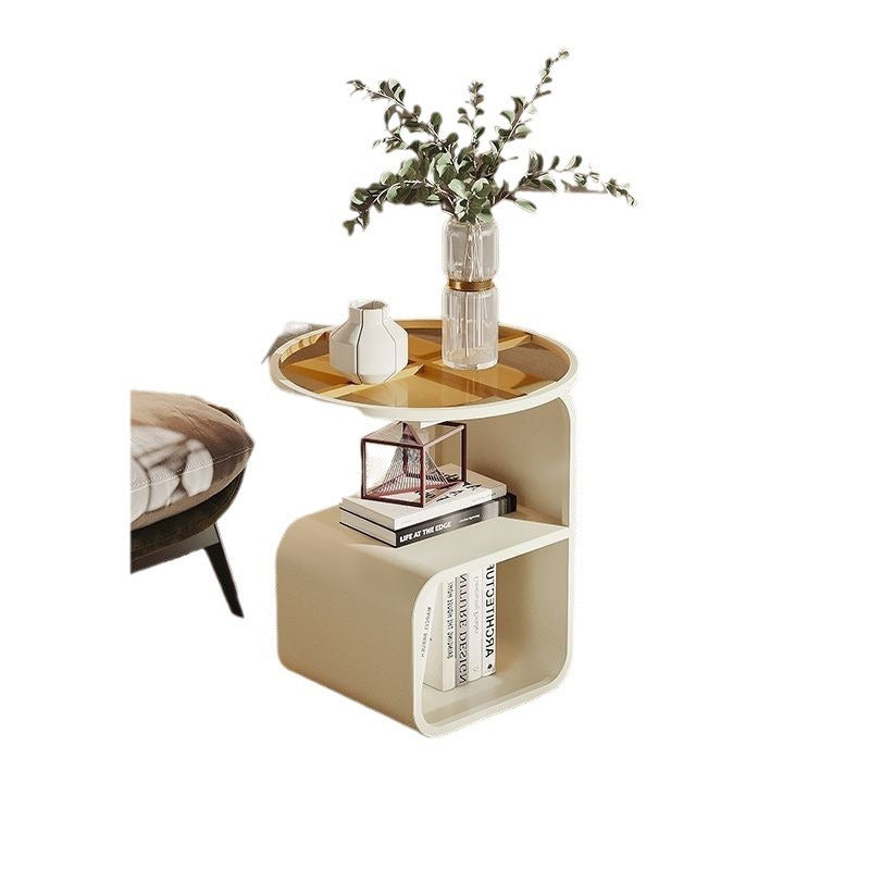 Compact round glass side table fitting in a narrow space between a sofa and a wall
