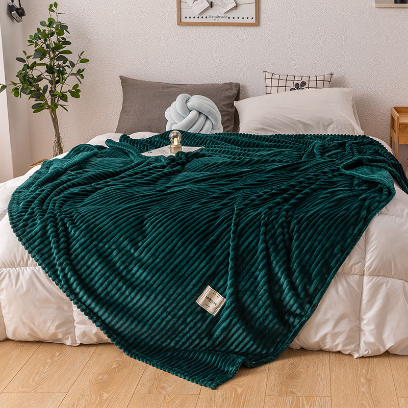 Queen size fleece throw blanket shown covering a full queen bed with side overhang
