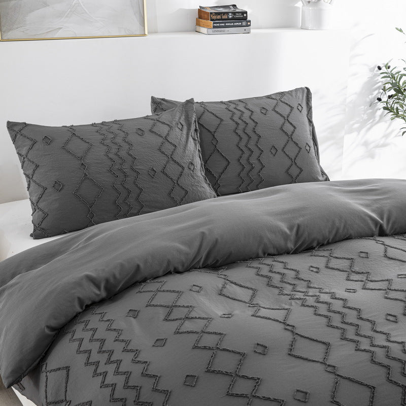 Gray patterned bedding set on a bed with pillows