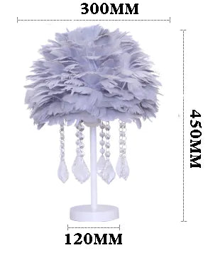 Soft pink luxury feather lamp glowing with warm light in a dark room