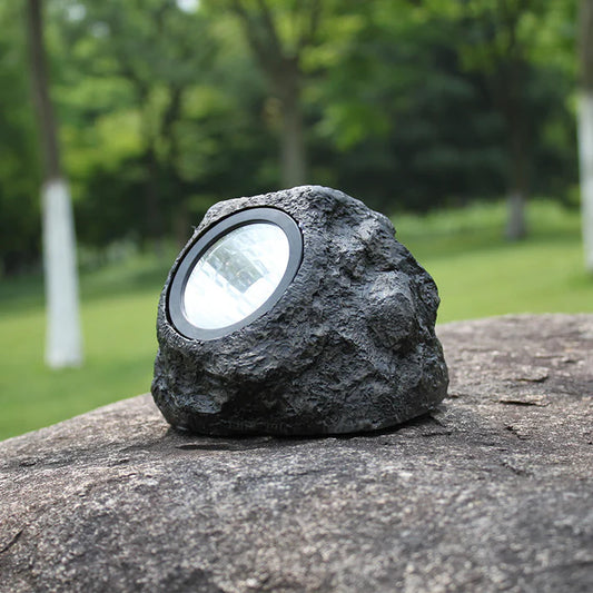 Solar simulation rock garden light placed on outdoor courtyard stone