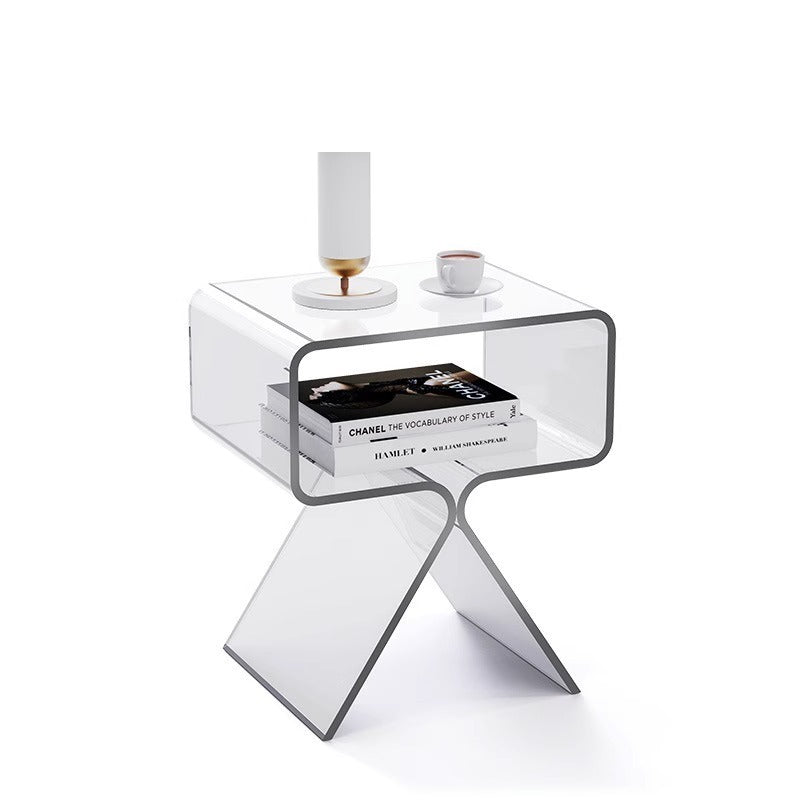 Smoked transparent black acrylic side table beside a dark sofa in a modern living room
