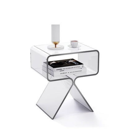 Smoked transparent black acrylic side table beside a dark sofa in a modern living room
