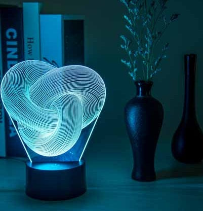 Twist acrylic 3D LED lamp in slow gradient color mode on a child bedroom nightstand
