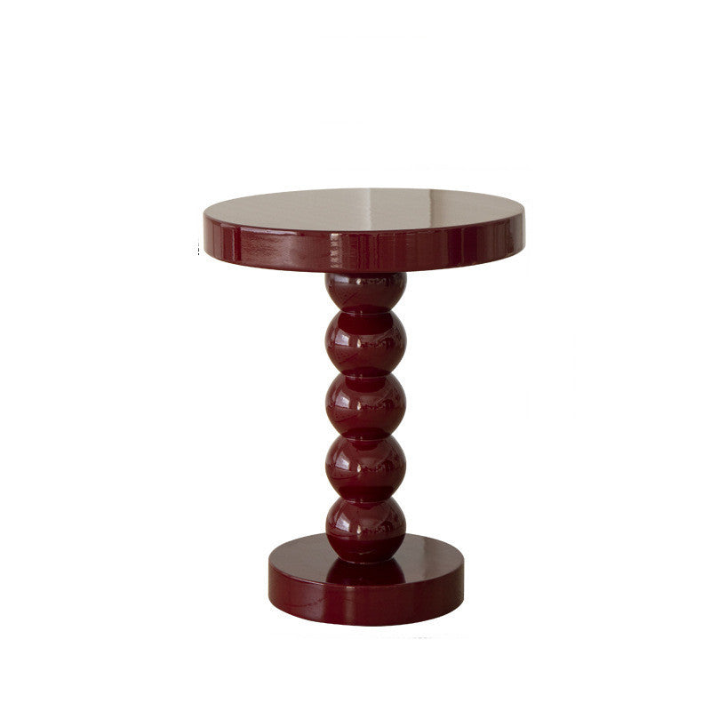 Black vintage round wood table as a sofa end table in a modern living room setup
