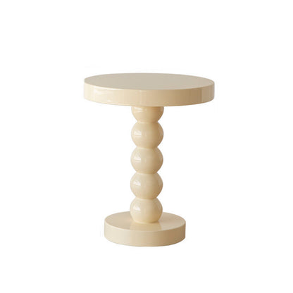 Vintage solid wood round bedside side table styled in a complete bedroom interior setup
