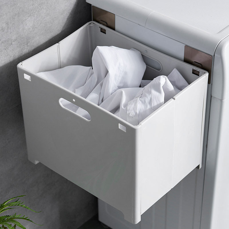 Close-up of the flat top shelf on the wall mounted laundry hamper holding a moisturizer and towel
