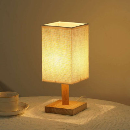 Lamp glowing in warm light mode on a cozy bedroom nightstand