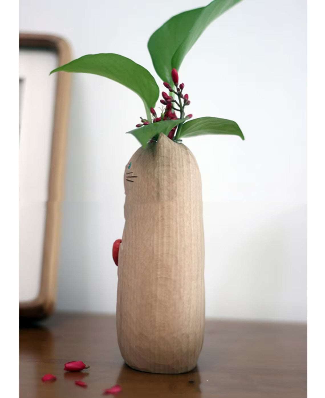 Close-up of wooden cat vase with fresh flowers arrangement