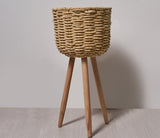 Medium woven straw floor pot on a balcony beside a chair with a green plant inside