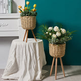 Natural straw floor planter styled in a boho bedroom corner with a dried flower arrangement