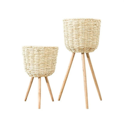 Medium woven straw floor planter holding a dried pampas grass arrangement in a bright hallway
